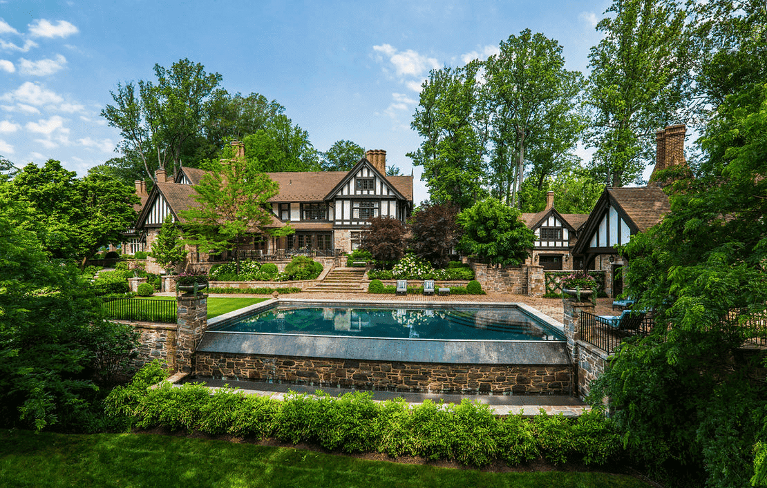 Large Tudor-style estate with clay roof tiles and landscaped pool area. House designed by Peter Zimmerman Architects - Clay tiles from Northern Roof Tiles