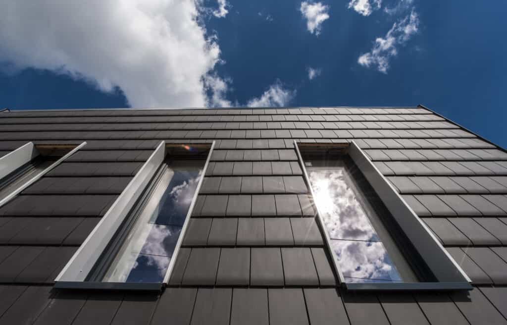 Modern building with Plana flat interlocking clay tiles installed vertically as wall cladding.