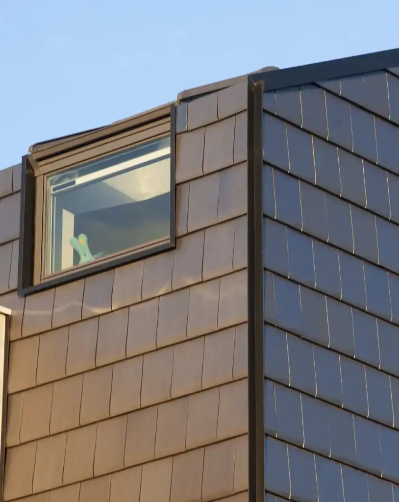 Vertical installation of Edilians flat clay tiles on a contemporary building exterior with window
