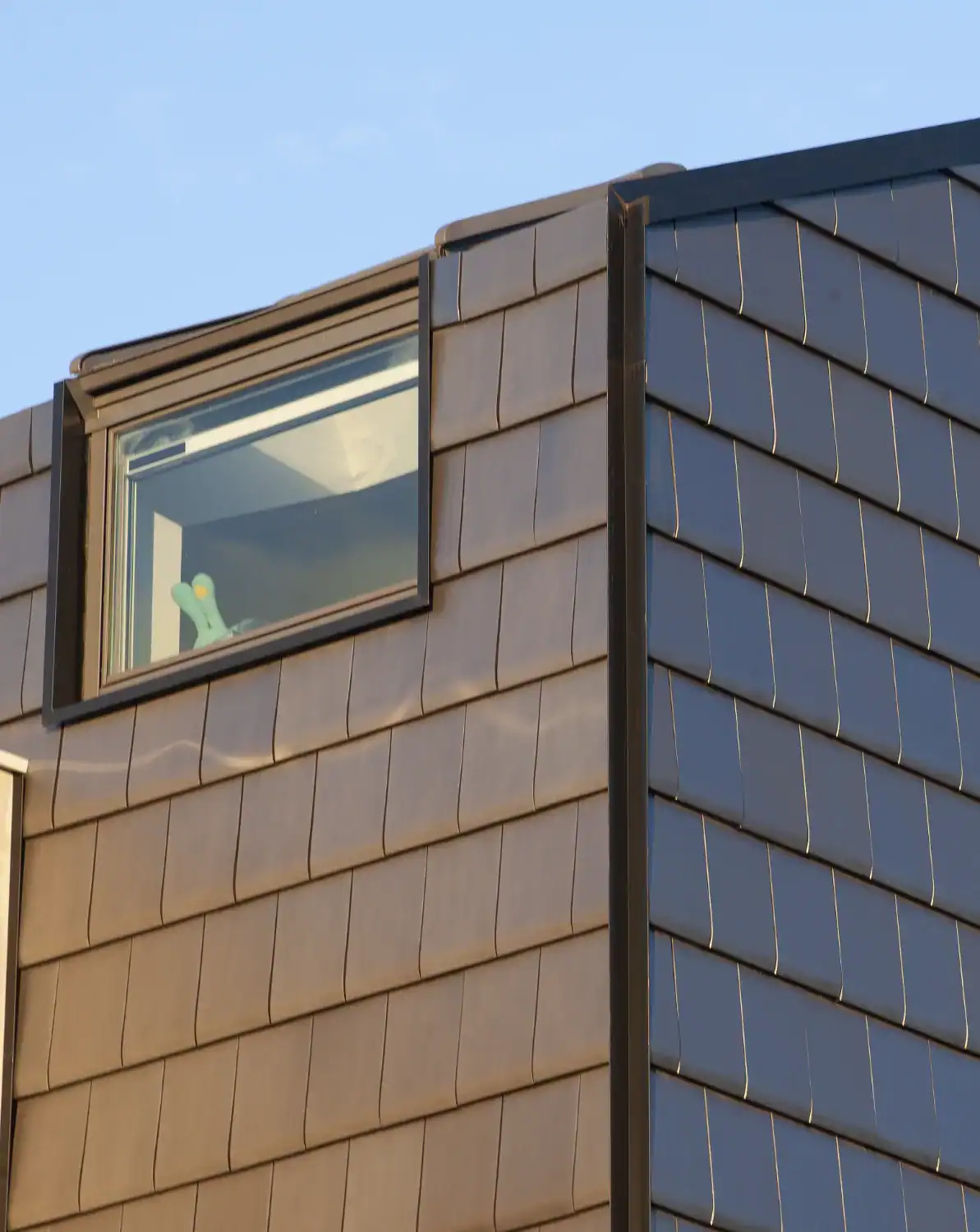 Vertical installation of Edilians flat clay tiles on a contemporary building exterior with window