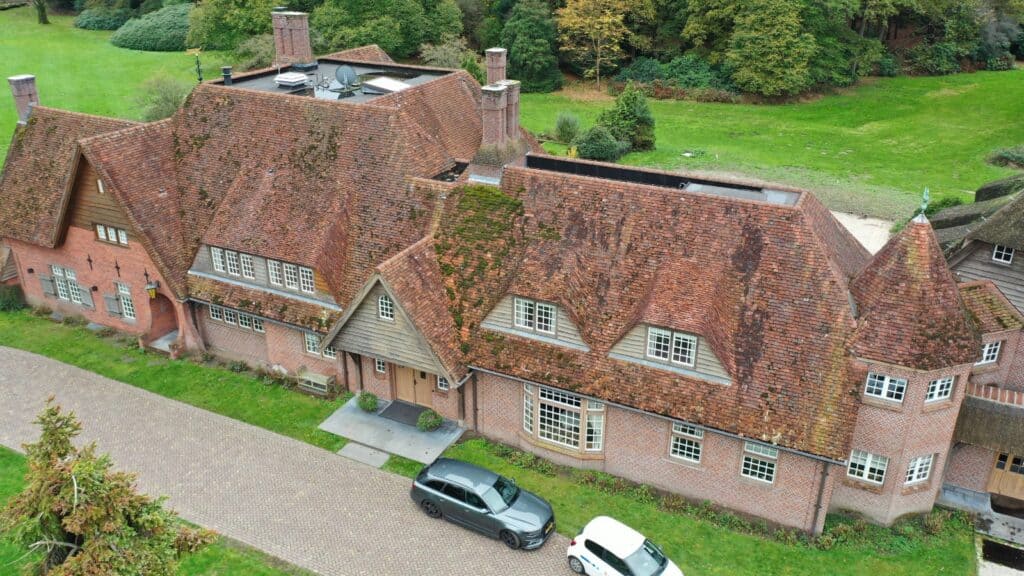 Historic manor house with original clay roof tiles from 1847 undergoing restoration